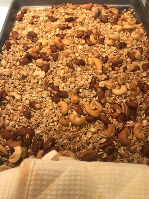 Granola fresh out of the oven on a sheet pan.